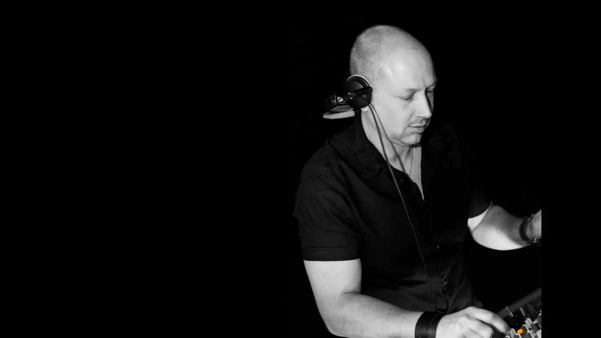 DJ Tom Royce mit Kopfhörern am Mischpult, Schwarz-Weiß-Aufnahme